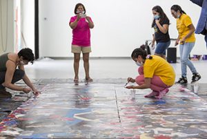 People with masks working on the mural